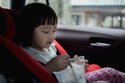 Boy looking at camera while sitting in car