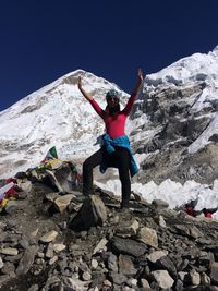 Full length of woman standing on rock against sky