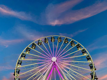 Low angle view of ferris wheel against blue sky