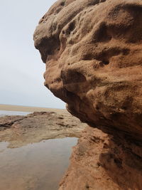 Rock formation on beach against clear sky