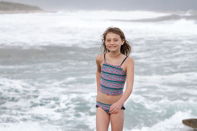 Portrait of smiling woman standing on beach