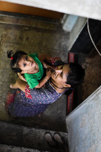 High angle view portrait of mother and daughter at home