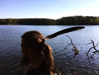 Rear view of woman in lake against sky