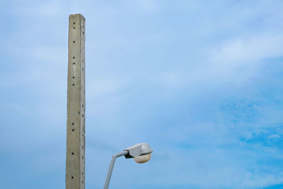 Low angle view of street light against cloudy sky