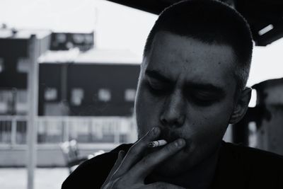 Close-up portrait of young man smoking