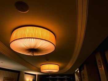 Low angle view of illuminated pendant lights hanging from ceiling