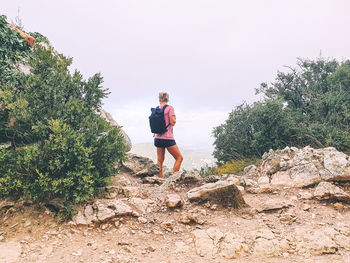 Female hiker standing next to the rock