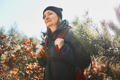 Woman enjoying hike on sunny vacation day. female walking through forest. spending summer vacation