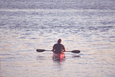 Rear view of man kayaking in sea