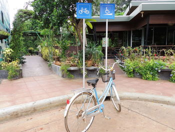 Bicycle parked on footpath by building in city