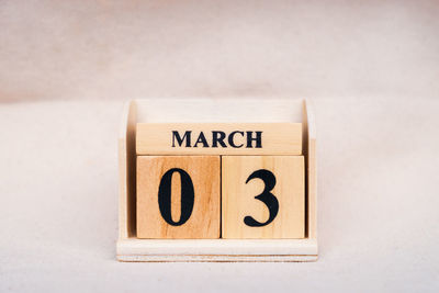 Close-up of information sign on table against white background