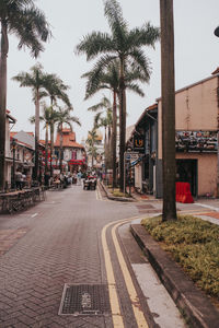 Empty road amidst buildings in city