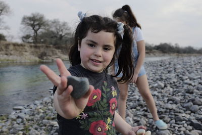 Portrait of a smiling girl holding water on land