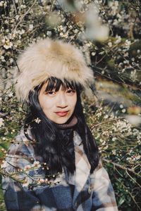 Portrait of woman wearing warm clothing by tree