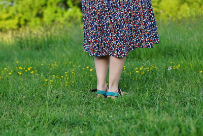 Woman with flower skirt close up bare legs in gras spring summer