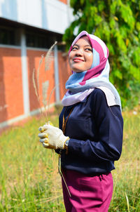 Portrait of smiling woman standing on field