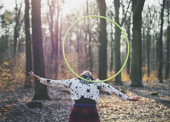 Woman balancing plastic hoop on her chest