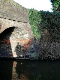 Arch bridge over canal against sky