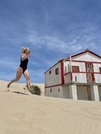 Full length woman running on the sand on the beach