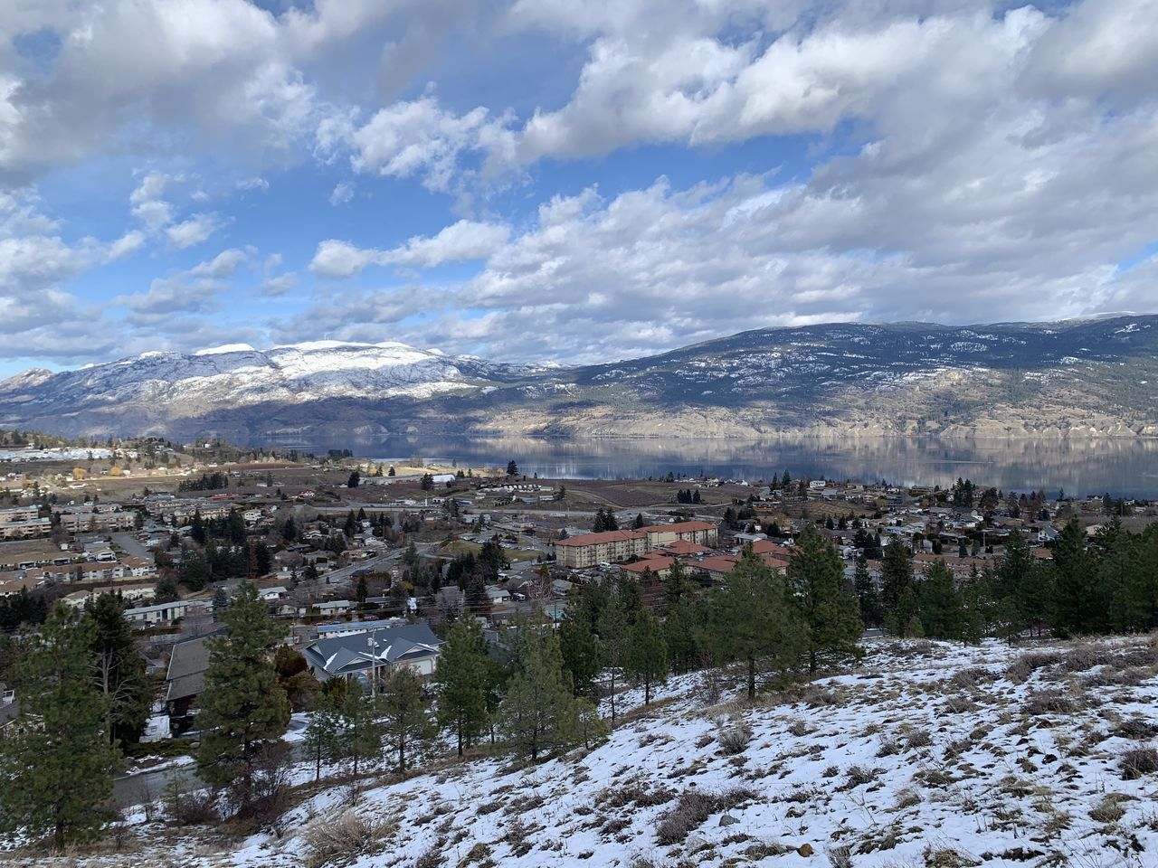 AERIAL VIEW OF TOWNSCAPE AND MOUNTAINS AGAINST SKY