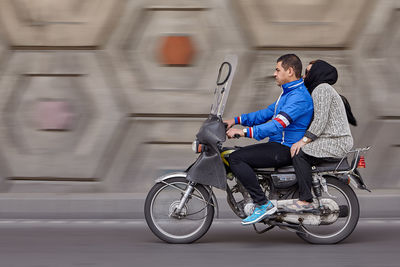 Side view of woman riding bicycle