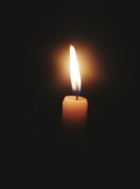 Close-up of lit candle in dark room