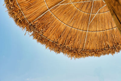 Low angle view of thatched roof against sky