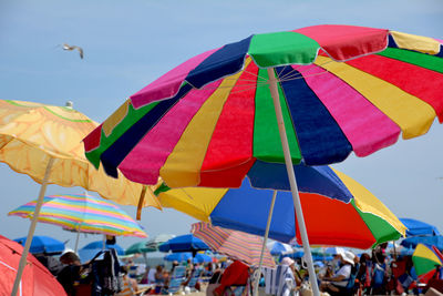 Multi colored parasols with people sitting in background