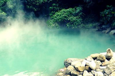 Steam emitting from lake in geothermal valley