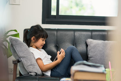 Boy sitting on sofa at home