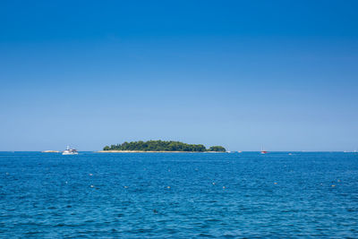 Scenic view of sea against clear blue sky