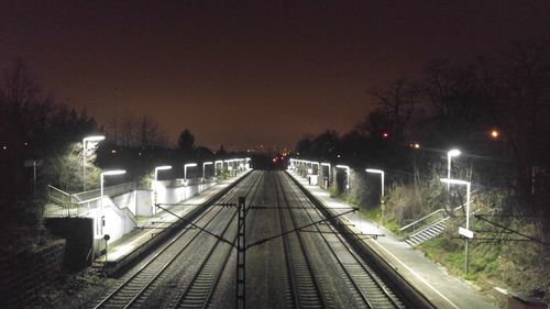 Railroad tracks against clear sky at night