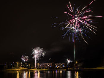 Firework display over river at night