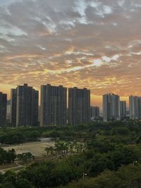 Buildings in city against sky during sunset