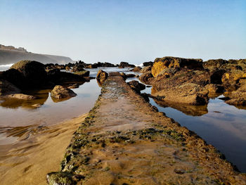 Scenic view of rocks in river against clear sky