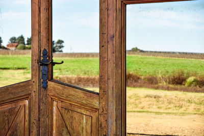 Scenic view of field against sky seen through window