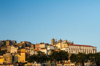 Buildings in city against clear blue sky