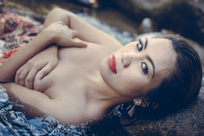 Close-up of beautiful woman lying in water