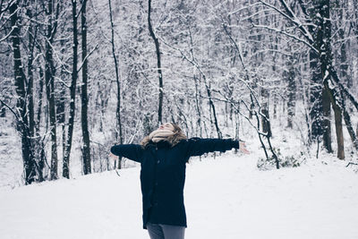 Woman in snow covered forest