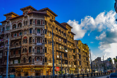 Low angle view of buildings against cloudy sky