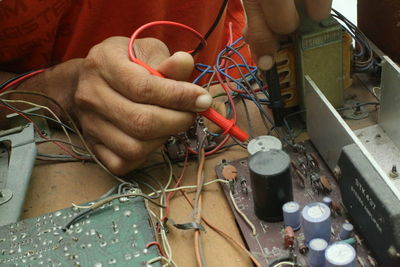Cropped hands of male technician repairing radio
