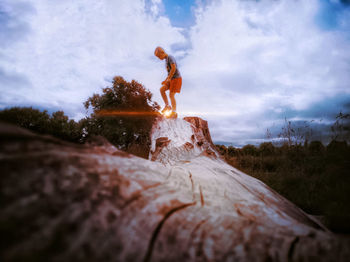Low angle view of woman standing on rock