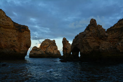 Rocks on sea shore against sky