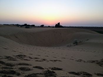 Scenic view of desert against sky during sunset