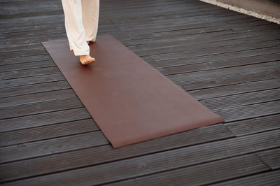 Low section of woman walking on hardwood floor