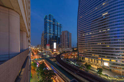 Panoramic view of city street and buildings against sky at dusk
