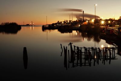 Silhouette boats in lake against sky during sunset