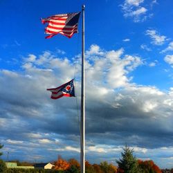 Low angle view of american flag against blue sky