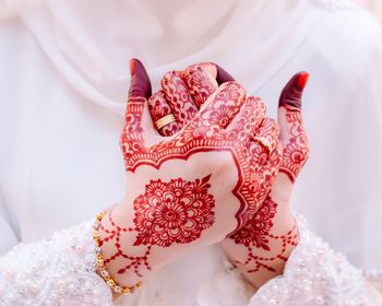 Midsection of bride with henna tattoo