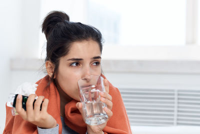 Portrait of woman drinking water from glass